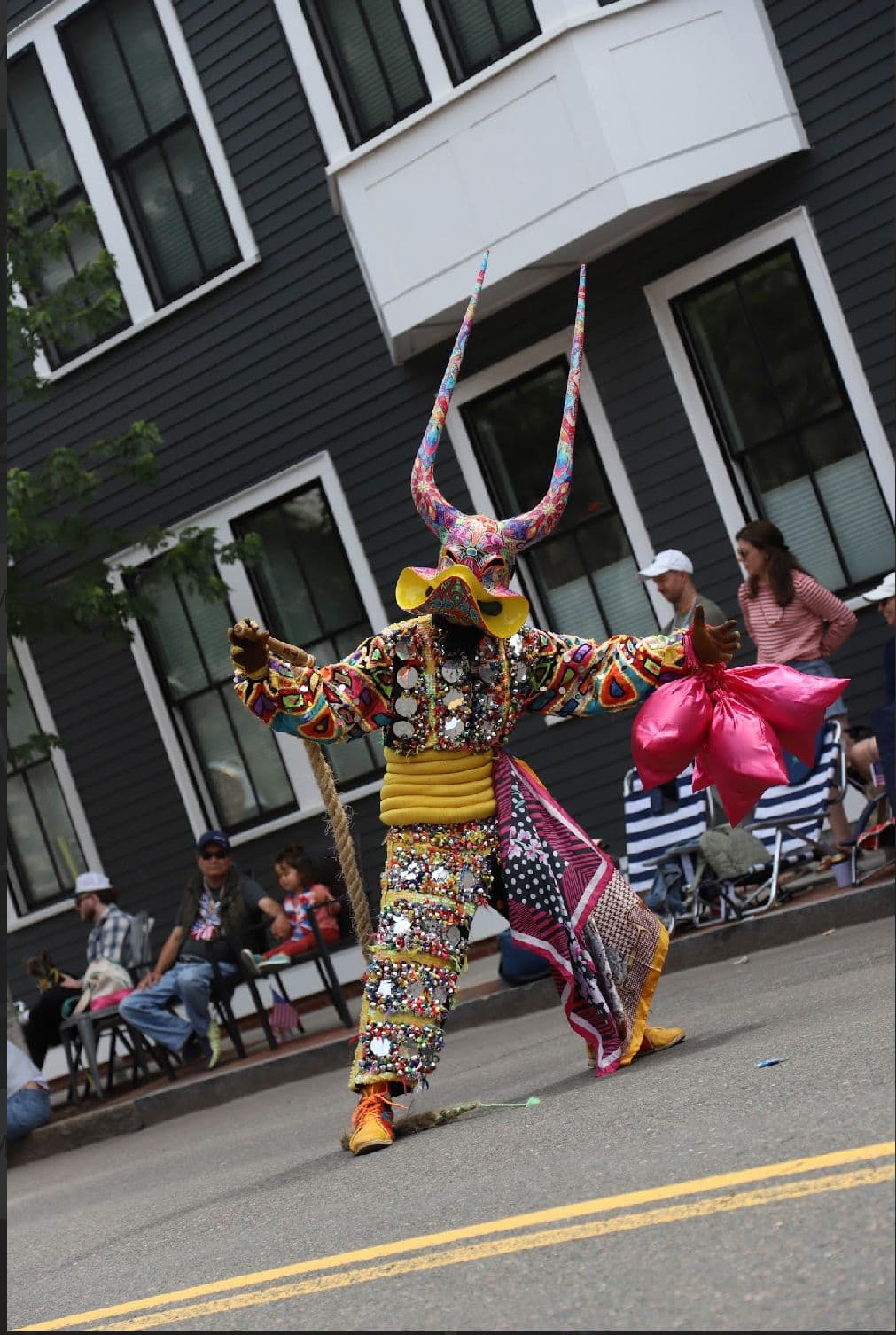 Lechón performer in a horned mask and beaded suit